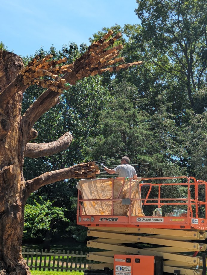 sculptor working on a scissor lift